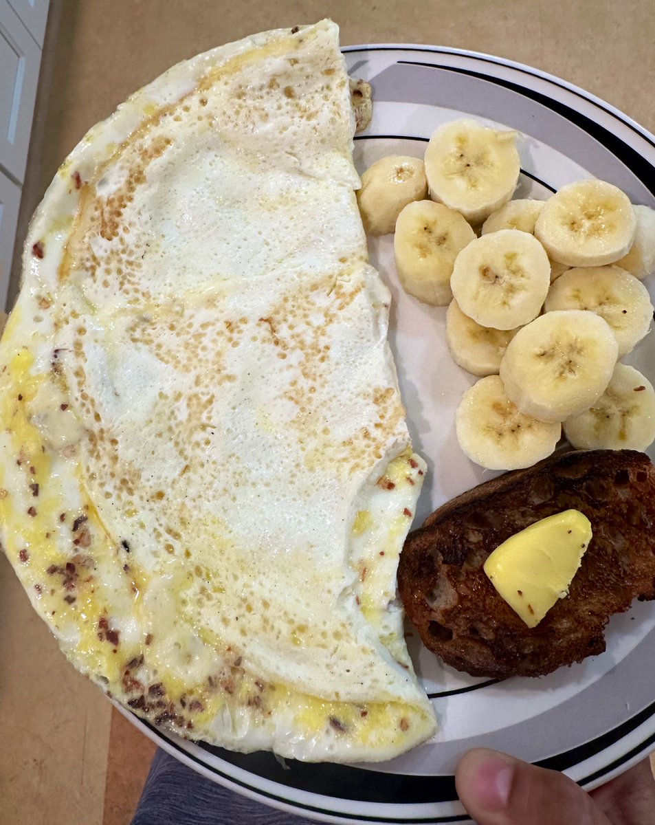 free_style_chef's tweet image. A giant spicy omelet with pepper jack cheese, toast with lots of butter, and banana. 

Yes, I happily consumed this for breakfast. 😋

#brekkie #eggs #homecooked