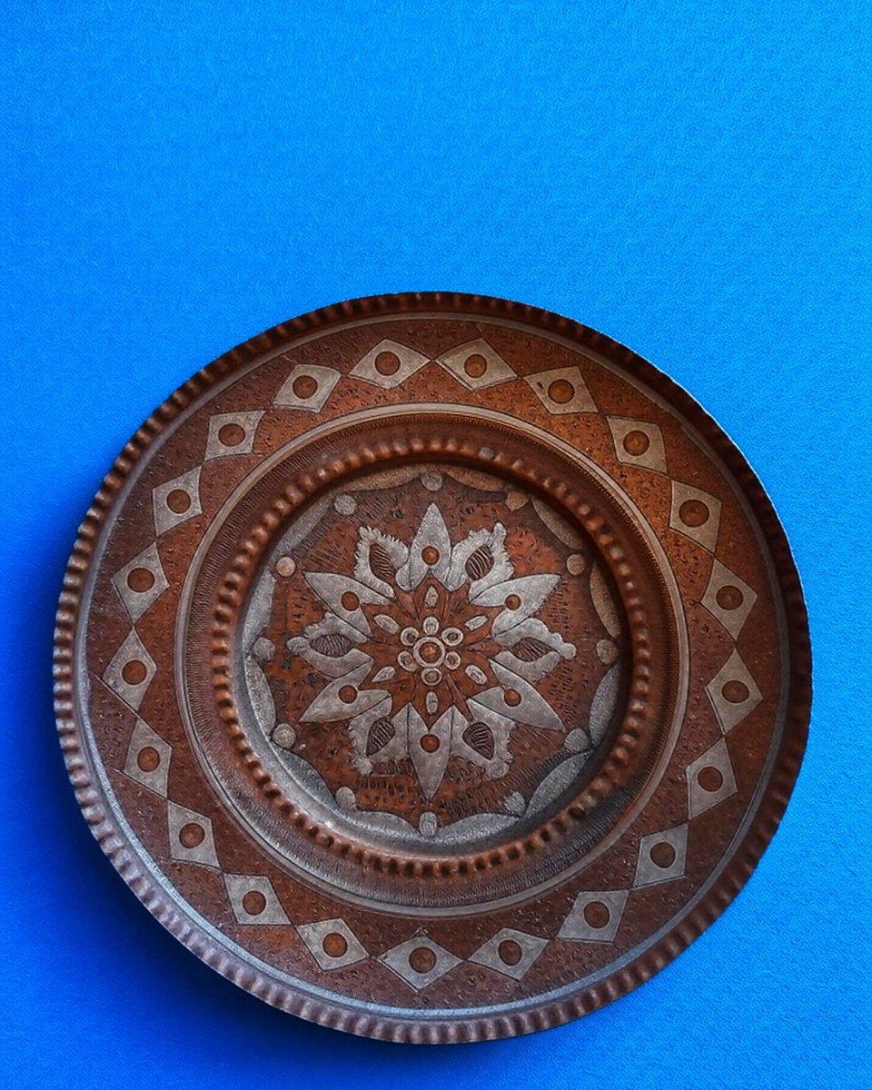 Copper20180711's tweet photo. This mid-20th century handcrafted copper plate features intricate inlay work in copper, a radiant floral center, geometric border patterns, and delicate wave &amp; dot details—true artistry and cultural heritage.
 #MiddleEasternArt #VintageCollectibles #CopperArt #Handmade #ArtDecor https://t.co/H5bPlVq5MH