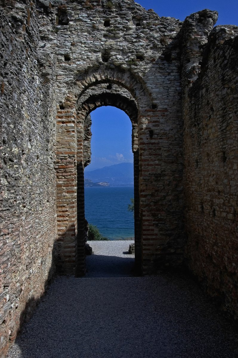#Roman #Lombardy #Lombardia

Narrow archways of a Roman villa offer view across Lake Garda at Sirmione in Lombardy, Italy. The villa, whose ruins are today collectively known as the Grotte di Catullo (Grottoes of Catullus), was built between end 1st century BC and 2nd century AD