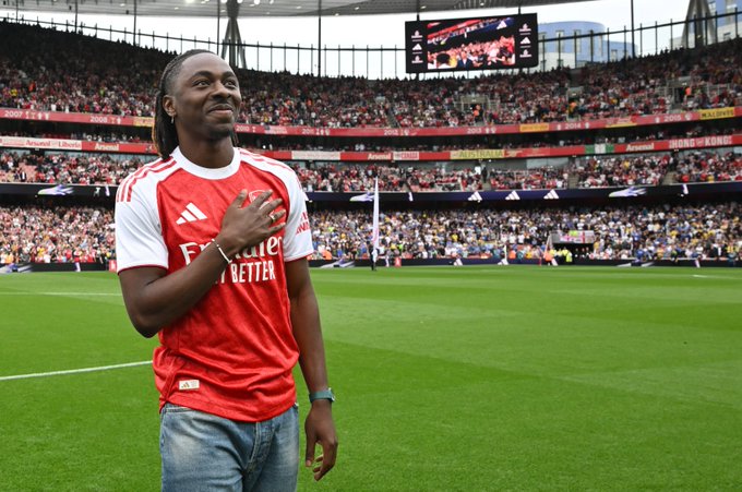 Eberechi Eze pats the badge ahead of the game at Emirates Stadium.