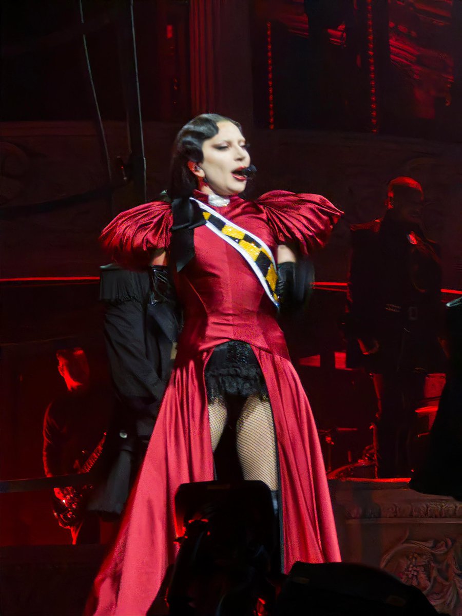 Lady Gaga is wearing a black-and-yellow checkerboard sash for