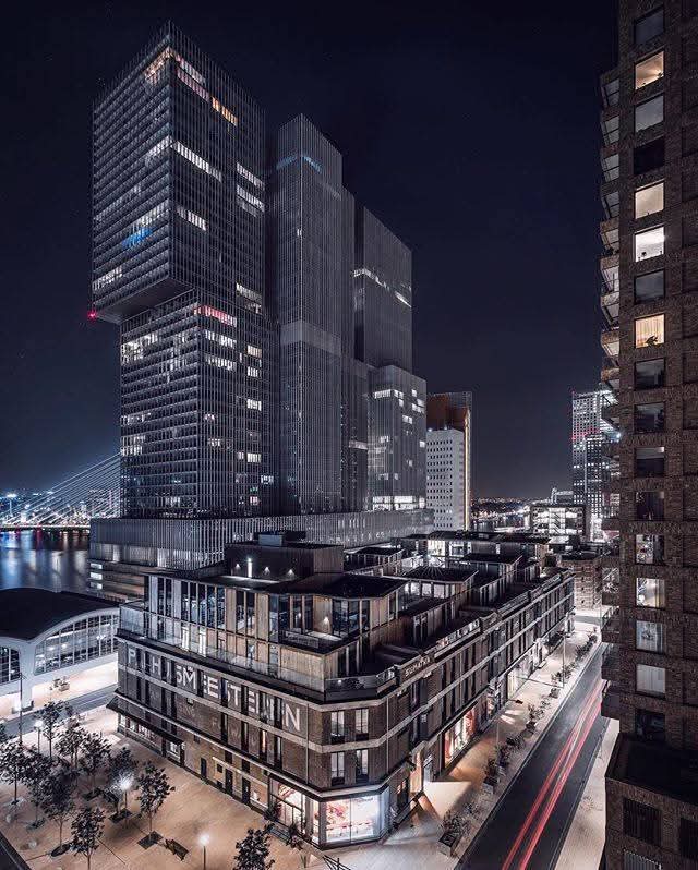 Avondopname van de Wilhelminapier met de rotterdam, en kpn gebouw, erasmusbrug, kop van zuid.