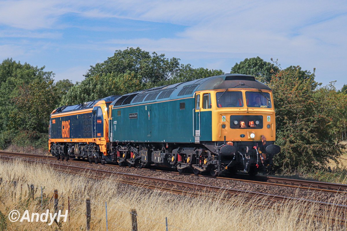 holtona72's tweet photo. The old &amp; the new passing Uffington, near Stamford, this lunchtime. @GBRailfreight #BrushType4 47727 'Edinburgh Castle/Caisteal Dhùn Èideann' drags brand new #Stadler dual mode locomotive 99002 as 0Q90 Leicester LIP to Peterborough Maintenance Shed. #GBRF #Sulzer 25/8/25 https://t.co/P1dQv9AYxU