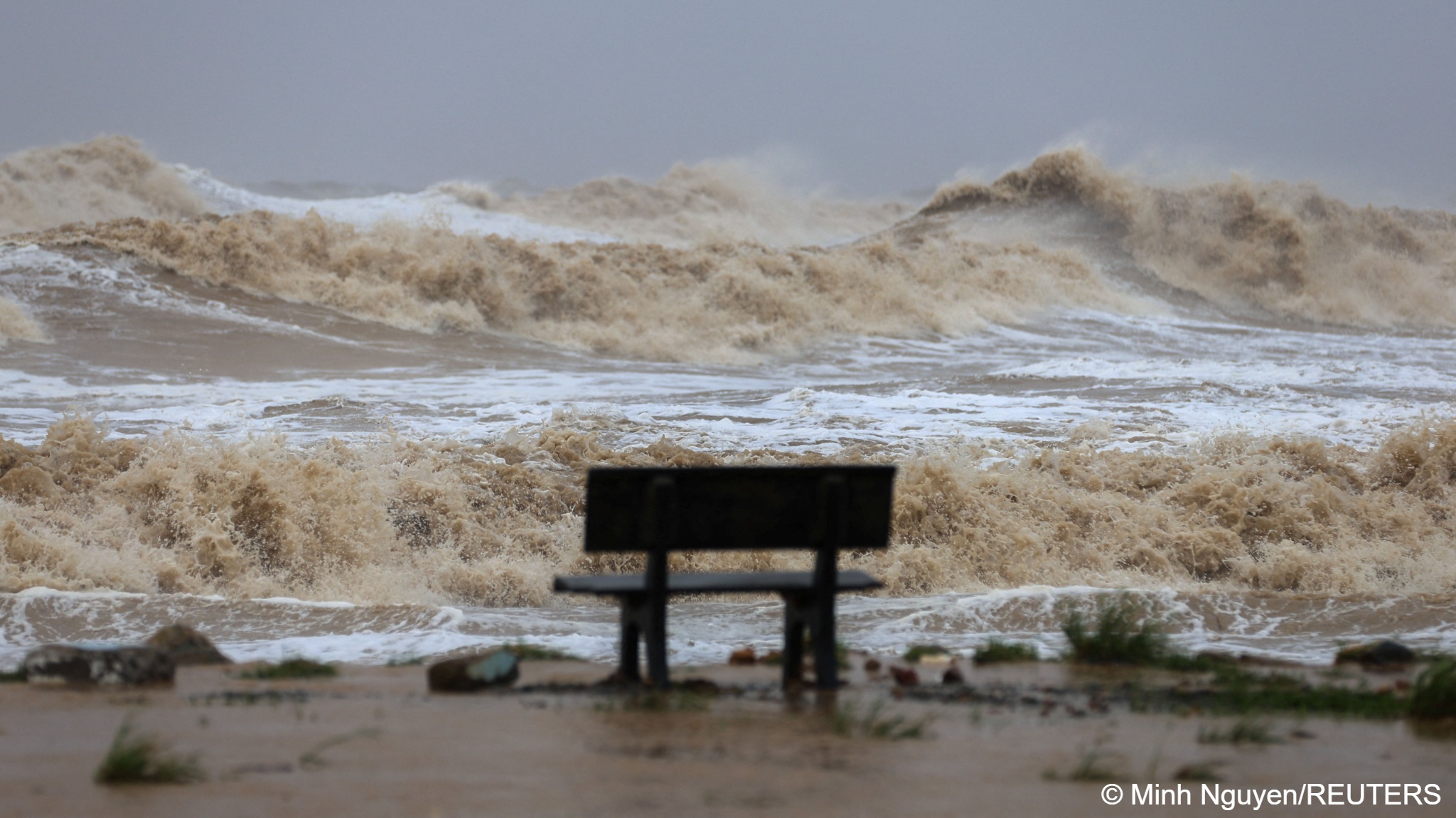 a bench in front of waves