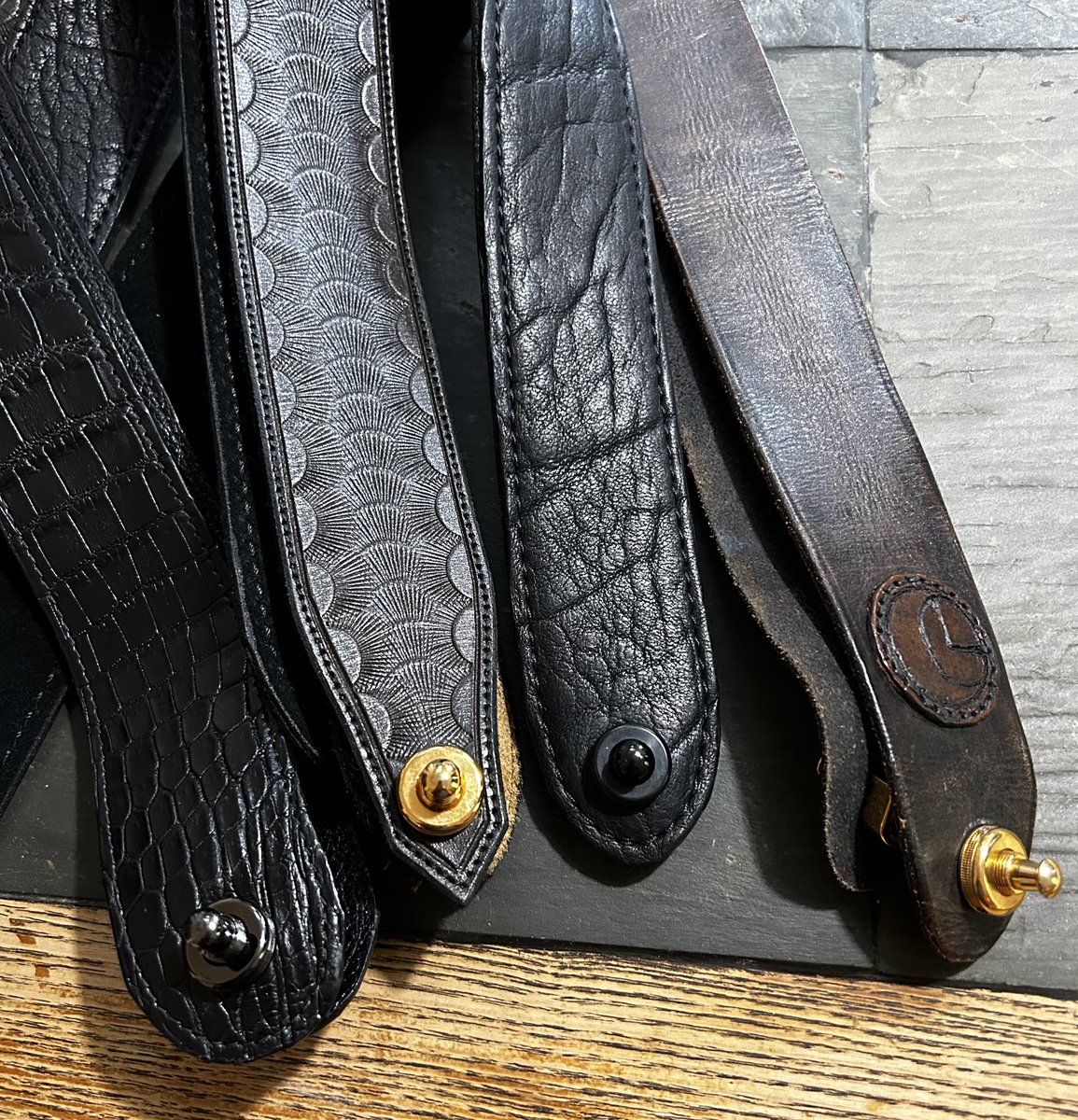 My guitar straps are all custom made to my specs.  They are not adjustable.  Being non-adjustable cuts down on excess leather and makes them much less bulky.  Also prevents anyone from changing my strap length.
