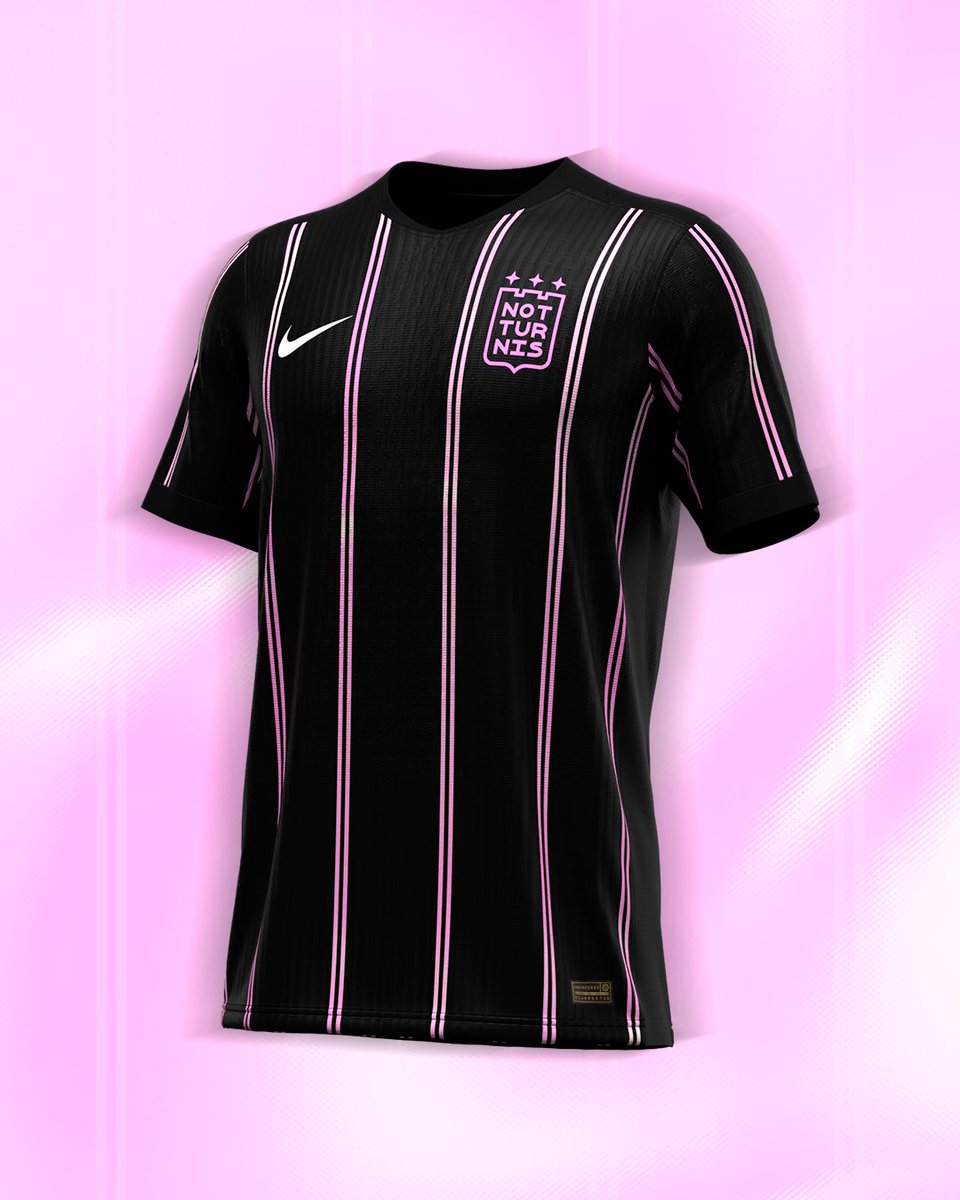 La camiseta titular, en un elegante negro, presenta sutiles bastones que combinan los colores del escudo con un delicado degradado, logrando una fusión moderna y elegante que realza cada detalle.