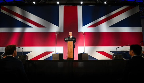 Cunningsplan's tweet photo. All I can see in the murkiness is Nigel in a pair of weirdly high-waisted brown corduroys...Oh, hang on, that's the lecturn... #weaksauce #wrongtrousers  #deform https://t.co/GCCjARqX1H