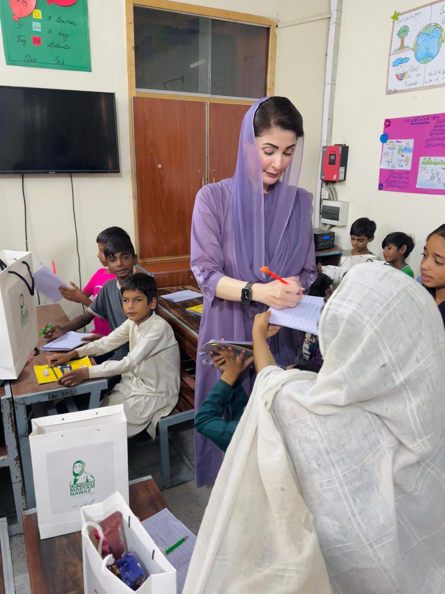 A child in the flood relief camp taking an autograph from CM Maryam Nawaz.
