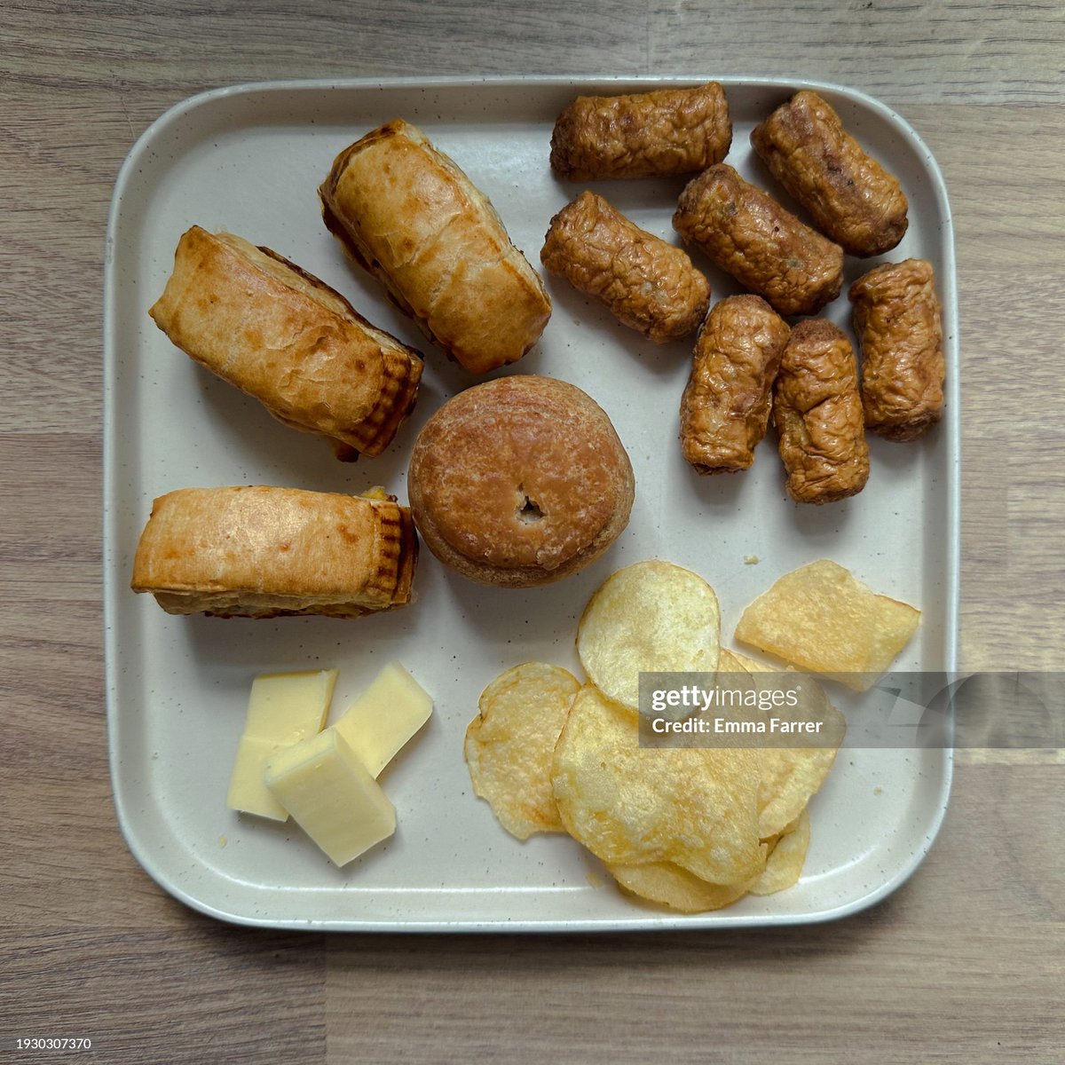 A plate with beige processed foods; crisps, cheese, cocktail sausages, sausage rolls and a pork pie. A selection of shop bought pre-made snacks is a meal sometimes known in the UK as “picky tea”. (2024)