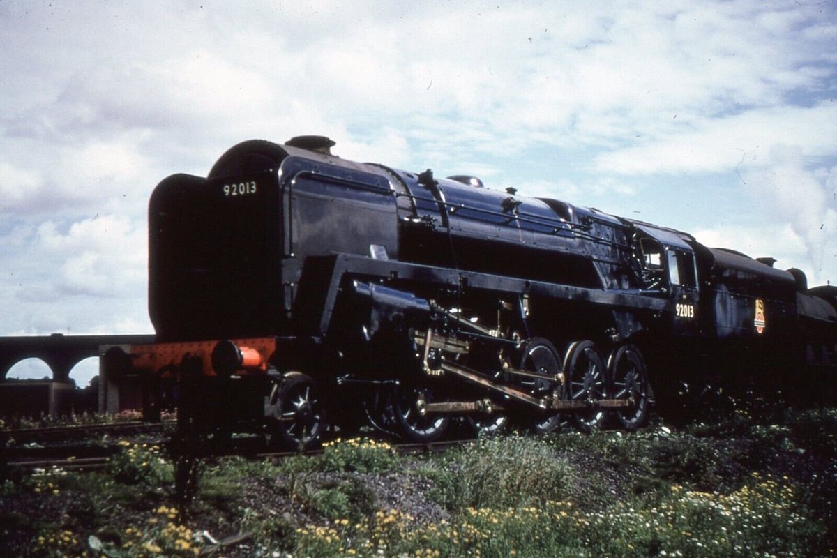Fresh from Crewe and bearing the glimmer of an engine still being run in, 9F 92013 captures the sunlight on a somewhat gloomy day at Rugby Shed in 1954. 92013 had begun service life at 31B March Shed only on 31st May of that year alongside four other 9Fs fresh from the works.