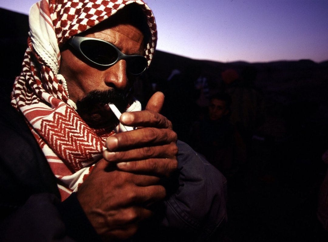 Palestinian man lights a cigarette, Palestine, 2000.