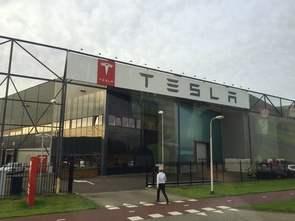 JStabentheiner's tweet photo. 2014 stand ich als Energietechnik-Student im Tesla-Werk in Tilburg.
Autos kamen damals in Einzelteilen aus den USA und wurden vor Ort zusammengesetzt, weil auf Einzelteile deutlich weniger Einfuhrabgaben anfielen als auf fertige Autos. In Tilburg gab es eine eigene Indoor-Teststrecke, auf der jedes Fahrzeug nach der Montage Probe gefahren wurde. 
Parallel dazu lief die enge Zusammenarbeit zwischen Tesla und Mercedes. Daimler war damals mit knapp 10 Prozent an Tesla beteiligt und verbaute den kompletten Tesla-Antriebsstrang in der elektrischen B-Klasse. Kein klassisches Joint-Venture, aber ein Projekt, das eindrucksvoll zeigt, wie nah beide Konzerne einmal zusammenarbeiteten, bevor Daimler seine Anteile 2014 verkaufte. Angesichts des aktuellen Wertes von Tesla wohl nicht die beste Entscheidung...

Wir waren völlig geflasht von der Technik. Noch Tage später haben wir über die Ladeleistung sowie die Leistung der Motoren, die Lautlosigkeit und die Effizienz diskutiert. 2014 lag die Ladeleistung an Teslas Superchargern bei maximal 120 kW. Heute erreichen Fahrzeuge wie der Porsche Taycan, Smart #5 oder der Kia EV9 400 kW. Mehr als das Dreifache!

Auch die Stückzahlen machen den Fortschritt sichtbar: 2014 wurden in Deutschland nur etwa 12.000 Elektroautos zugelassen. 2024 waren es über 500.000 - mehr als das Vierzigfache! Von der heutigen Ladeinfrastruktur hat man damals geträumt. 

Für mich war schon damals klar: Das ist die Zukunft!

Schneller als ich gedacht hätte, ist es Realität geworden. Damals hätte ich niemals gedacht, dass ich heute selbst einen Tesla fahren würde. Was 2014 für viele noch wie ein ambitioniertes Nischenprojekt wirkte, ist längst Teil unseres Alltags.

Natürlich gibt es noch Baustellen in der E-Mobilität. Für mich sind vor allem die Themen Ladepreise und Ladekartenwirrwarr aktuell die größten. Aber wer die Technik versteht, weiß: Wir sind auf einem guten Weg. Viele Dinge sind eher eine Frage der Regulation. Bei der Ladeinfrastruktur werden wir eine ähnliche Revolution brauchen wie 2017 beim EU-Roaming in den Mobilfunknetzen. Die EU muss klare Vorgaben machen, dass überall nur per Kreditkarte oder Plug&Charge mit hinterlegter Kreditkarte bezahlt werden darf. 

Wenn der Fortschritt der letzten zehn Jahre anhält, dann ist die Debatte um 2035 längst erledigt. Bis dahin hat sich die E-Mobilität vollständig durchgesetzt.