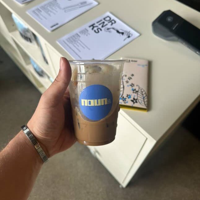 手持 Noun Coffee 咖啡杯