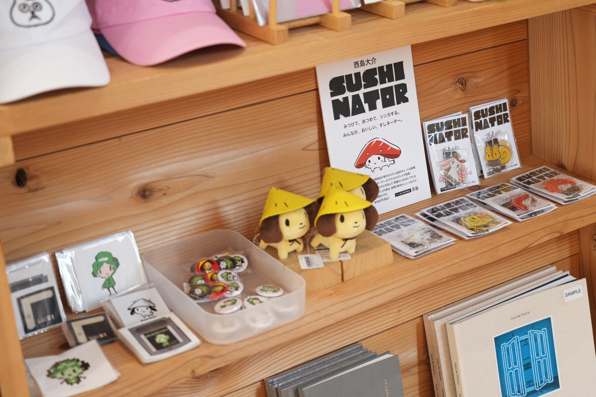 西島大介さんの「すしネーター」の販売が広島市現代美術館のミュージアムショップ「339」さんで始まりました。作家ゆかりの地ゆえの充実のコーナー展開。フンくんぬいぐるみや無題さんグッズも並んでいます！ 
#すしネーター ＃西島大介