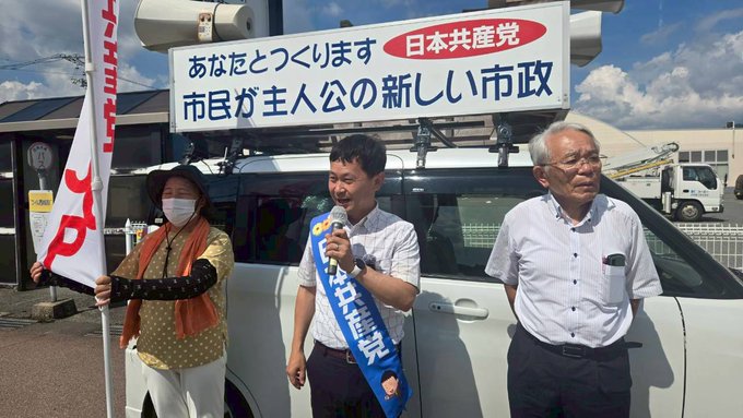 Six people sitting around a wooden conference table, holding documents and bottled drinks. A globe, clock, and tiger painting are on the shelves behind them. Three people standing in front of a white vehicle with a sign reading "JA Hiroshima" and Japanese text, holding flags and a microphone. One person wears a blue sash with Japanese text.