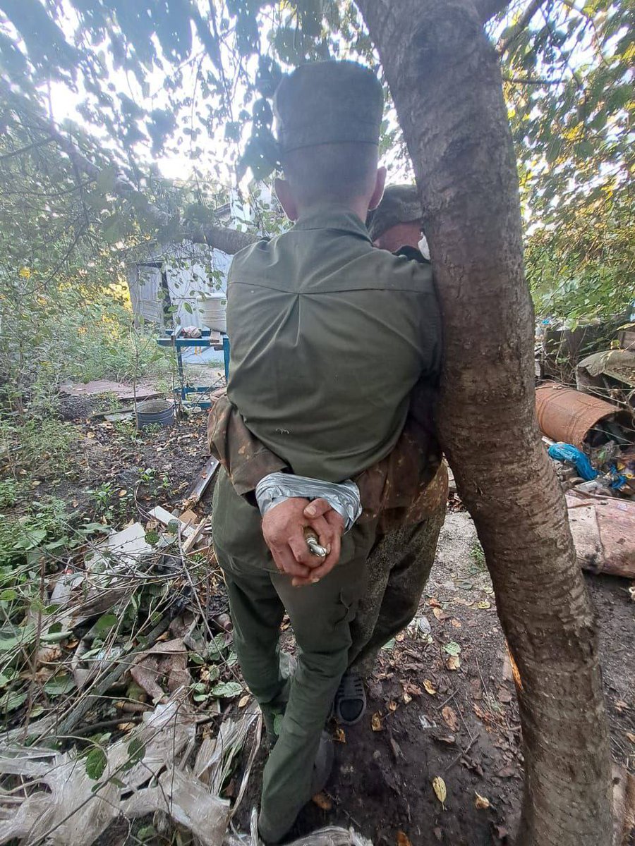 1/ Russian warblogger Alexander Garmaev has published a photo showing what he says are two Ukrainian POWs tied together with sticky tape, with one of them being made to hold a primed hand grenade which will explode if either try to escape or if it is dropped. ⬇️