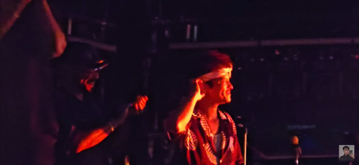 Printei essa tela de um video de uns dos shows do B no Brasil, tava escuro, clareei a foto e ele estava com esse sorrindo lindo e  orgulhoso olhando a apresentação do panda! A como ele foi feliz aqui! 🥹