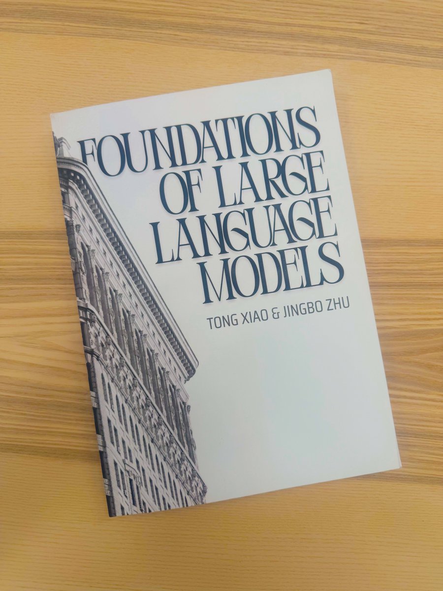 印在木桌上的《Foundations of Large Language Models》纸质书照片