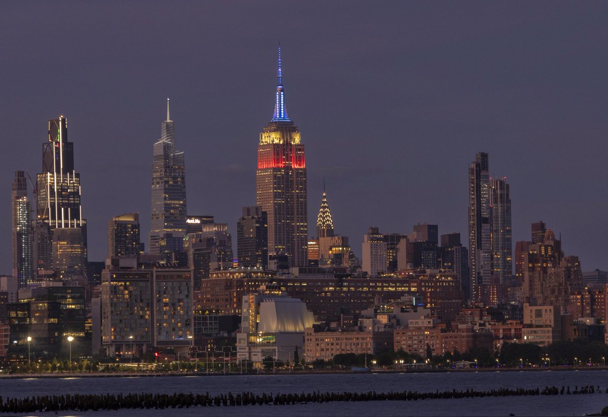 Four views of New York City at sunset Sunday evening shows the sun reflecting off One World Trade Center, flags at half mast in Liberty State Park behind the Statue of Liberty, the sky reflecting off lower Manhattan and the Empire State Building lit for Labor Day #newyorkcity