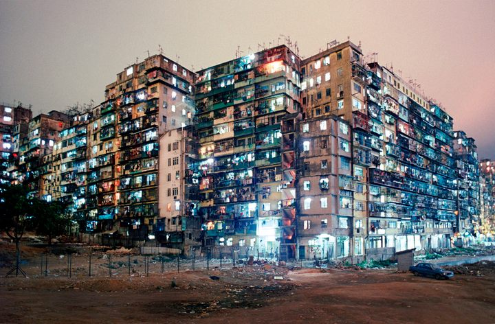 Estou completamente fascinado com a Cidade Murada de Kowloon.

•Simplesmente 1.200.000 de habitantes por km²,
•Prédios tão próximos que haviam pontes internas permitindo atravessar toda a cidade sem sequer tocar o chão,
•Uma cidade viva, com médicos, restaurantes e puteiros.