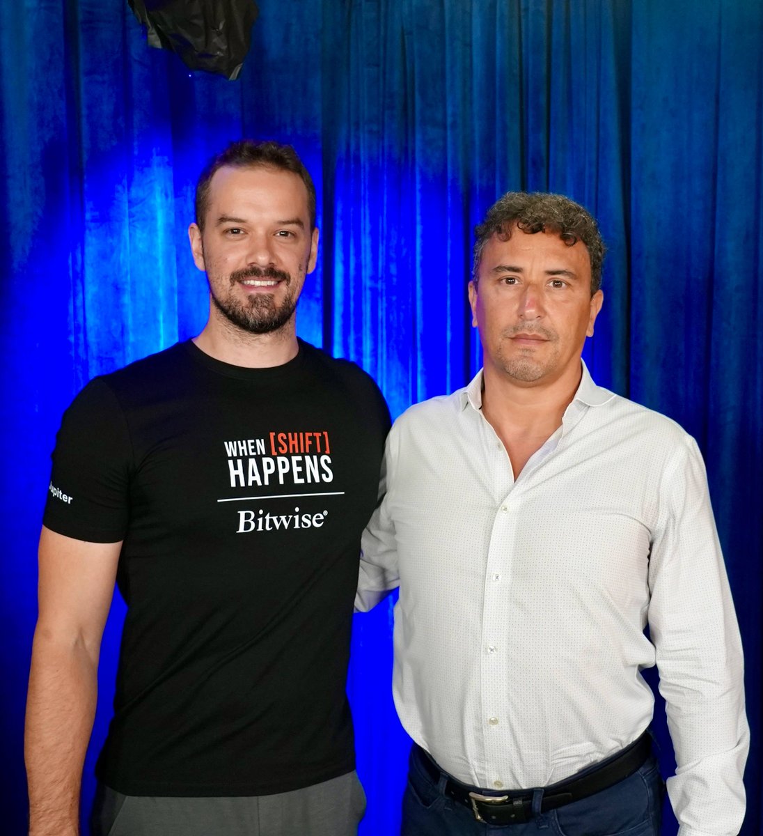 Kevin from When Shift Happens Podcast posing with Emin Gün Sirer of Ava Labs against a blue backdrop