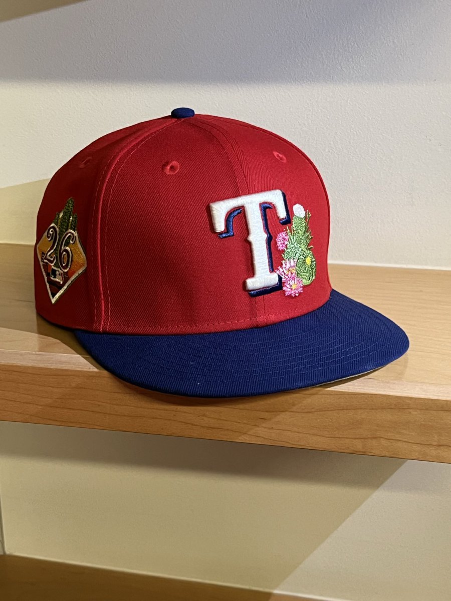 Evan_P_Grant's tweet photo. The Rangers spring training hats I guess were conceived on a mountain top where the cactus flowers grow. https://t.co/G1s5TW8Rqs