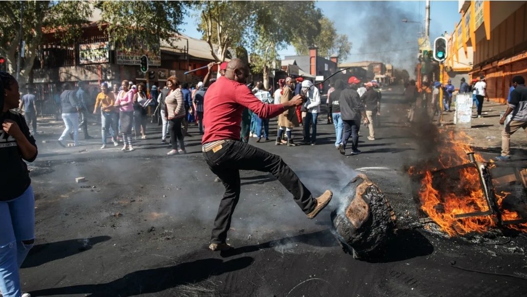 RiseAgainstEvil's tweet photo. One side, raging mobs torching streets, kicking burning wreckage, looting and destroying everything in sight. Pure chaos, smoke choking the sky, flames devouring property. They walk away with no repercussions. 

The other side, orderly, peaceful men marching with flags, heads held high, demanding dignity and rights; no violence, no destruction.Yet they end up in jail and court for daring to stand up. 

The peaceful ones go to jail. The violent destroyers? They roam free. 

This is persecution. This is a government that protects the arsonists and punishes the innocent. A regime so rotten it crushes law-abiding citizens while giving rioters a free pass. It's a weaponized system.