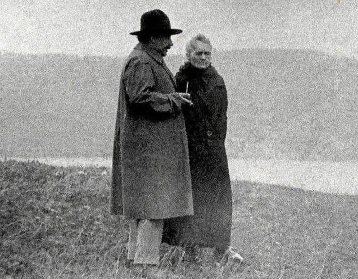 redhistoria's tweet photo. Albert Einstein y Marie Sktodowska Curie recordando junto a un lago en 1929...

Einstein y Curie no solo eran colegas, sino también viejos amigos que se movían en los mismos círculos de la física de principios del siglo XX. Ambos ya habían transformado la comprensión humana del mundo natural.

Einstein había transformado la física con sus teorías de la relatividad, mientras que Curie había descubierto el reino invisible de la radiactividad, trabajo que le valió dos Premios Nobel en dos campos científicos distintos. Sin embargo, aquí no hay rastro de laboratorios ni conferencias. En cambio, se yerguen simplemente como dos pensadores envejecidos, envueltos en gruesos abrigos, hablando en voz baja contra un paisaje brumoso.

Para 1929, ambos habían superado no solo batallas científicas, sino también tormentas personales. Curie había soportado la muerte de su esposo Pierre y, posteriormente, un duro y público escándalo. Einstein había huido del creciente antisemitismo en Alemania y se enfrentaba a las crecientes tensiones que lo llevarían a abandonar Europa por completo. Su resiliencia compartida creó un vínculo que trascendió la ciencia. Se admiraban profundamente. Einstein defendió a Curie durante los ataques a su persona, elogiando su dignidad y fortaleza cuando otros intentaron menospreciar su obra.

Momentos como esta fotografía nos recuerdan que los gigantes de la historia vivieron vidas humanas plenas, con amistades, preocupaciones y escasos momentos de paz. El lago que se extiende tras ellos es tranquilo y amplio, un suave contraste con la intensidad de los descubrimientos que definieron sus mundos.

En 1911, cuando Curie se enfrentó a un violento escándalo mediático, Einstein le escribió una carta privada instándola a ignorar a sus críticos, llamándolos "reptiles" y elogiando su brillantez como una de las pocas mentes que respetaba plenamente.

© Historical Photos