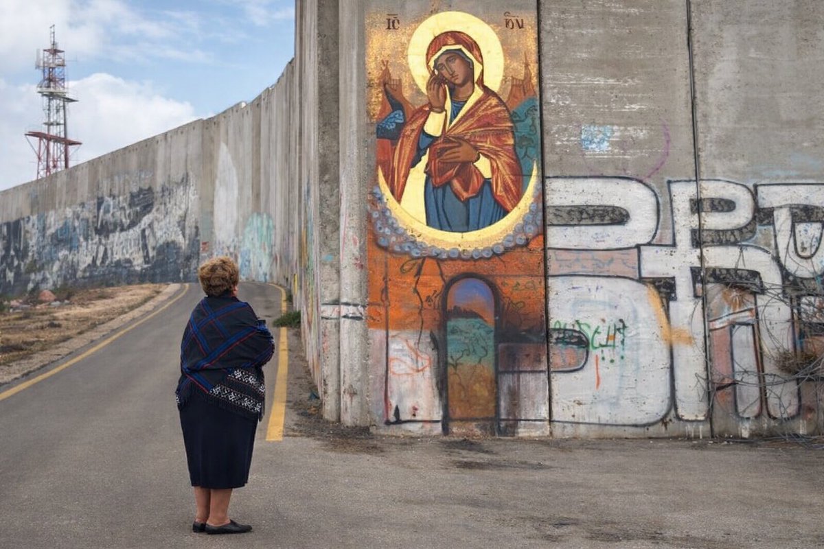A Palestinian Christian woman standing before the Separation Wall, in front of the icon “Our Lady of the Wall”. 

Bethelem, Palestine 🇵🇸