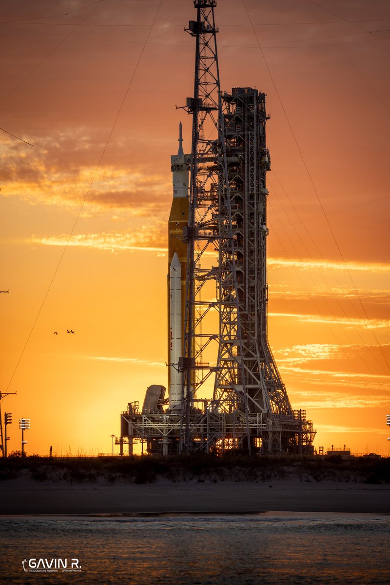TheLaunchPadX's tweet photo. Golden hour on the Space Coast.  

NASA’s Space Launch System stands on LC-39B awaiting its next Wet Dress Rehearsal. This rocket will carry humans around the Moon for the first time since Apollo!

Hard to believe this isn’t a render…
It’s real, It’s happening, We are going back! 

📸: Gavin (@tweetsiphotos) for @TLPN_Official
