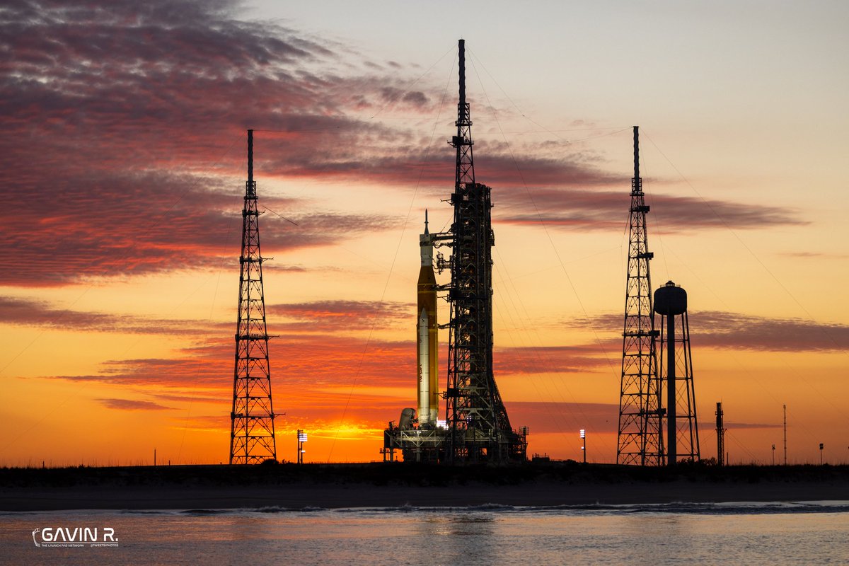 TheLaunchPadX's tweet photo. Golden hour on the Space Coast.  

NASA’s Space Launch System stands on LC-39B awaiting its next Wet Dress Rehearsal. This rocket will carry humans around the Moon for the first time since Apollo!

Hard to believe this isn’t a render…
It’s real, It’s happening, We are going back! 

📸: Gavin (@tweetsiphotos) for @TLPN_Official