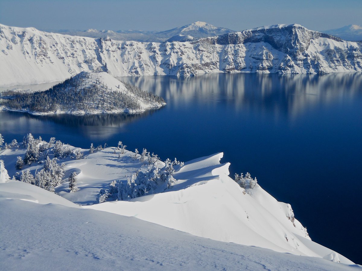 Interior's tweet photo. There’s no better time to experience Crater Lake National Park than winter. ❄️ 

With an average of more than 500 inches of snow each year, the park transforms into a striking winter landscape. Gaze in wonder at its blue waters, vividly contrasting against the surrounding snow. https://t.co/X539ZKDQnz