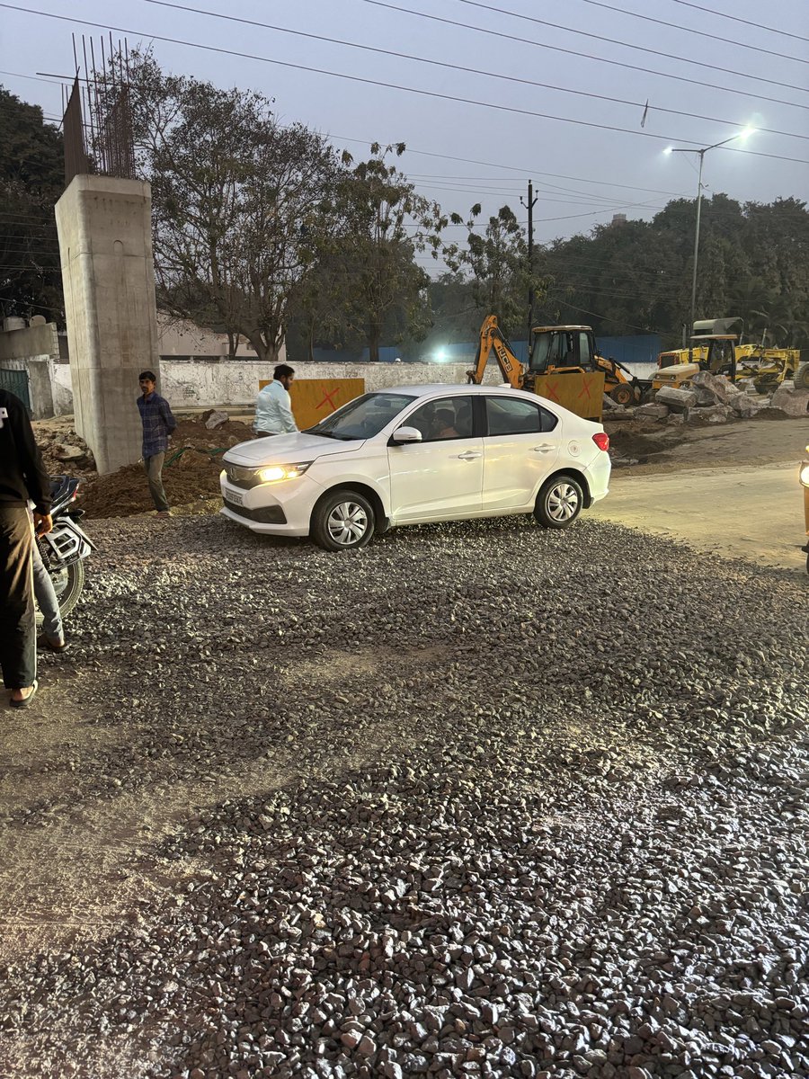thanman09's tweet photo. Due to elevated corridor construction on NH-44, a 100m unpaved road ends in a sudden ~1-ft limestone pole, creating a serious safety risk. Cars are getting stuck, bikes struggle, and a biker has been injured. Urgent barricading and warning signage needed.@HMDA_Gov @TelanganaCOPs https://t.co/zvw50kzuNE