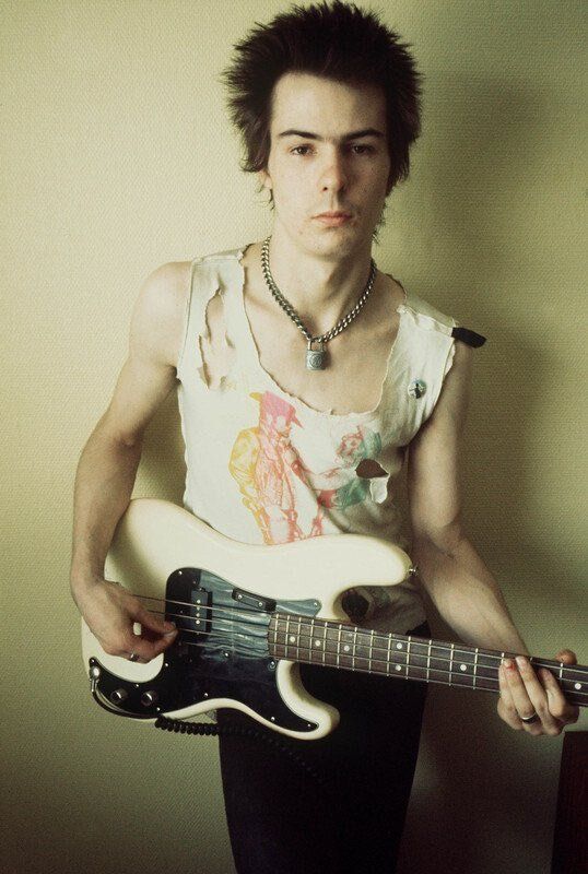 Sid Vicious in a Swedish hotel room, 1977. Photographer Dennis Morris created this "studio" shot on the fly by moving the hotel furniture and using the plain wall as a backdrop. Sid’s only response when asked for the photo? "Yeah, alright."