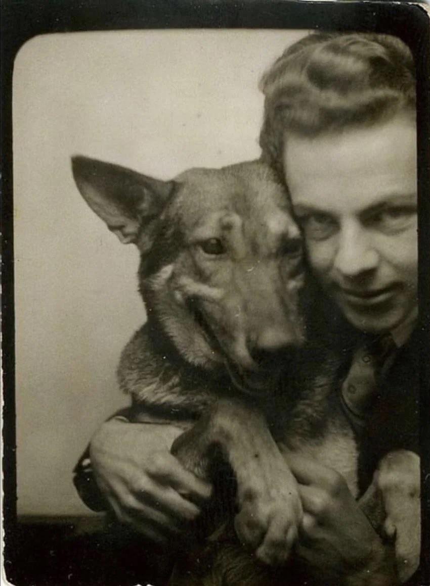 A man and his dog in a photo booth from 1943