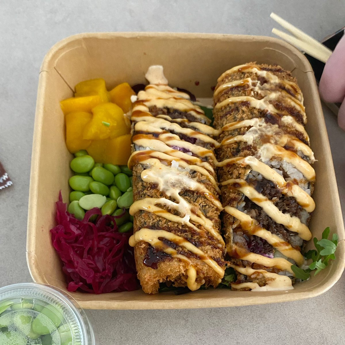 mame_swe's tweet image. 同僚が寿司ブリトーなるものを出前。「おめー、そんなの寿司じゃねーよ😭殴ったる😭😭」と怒りつつも、やはり日本人として味見。もちろん不味くはないんだけど、具が肉なら酢飯じゃない方が良いかも。弁当箱のなかの黄色いのたくあんかと思ったらマンゴー🥲

北欧風恵方巻きとして流行らせて✨