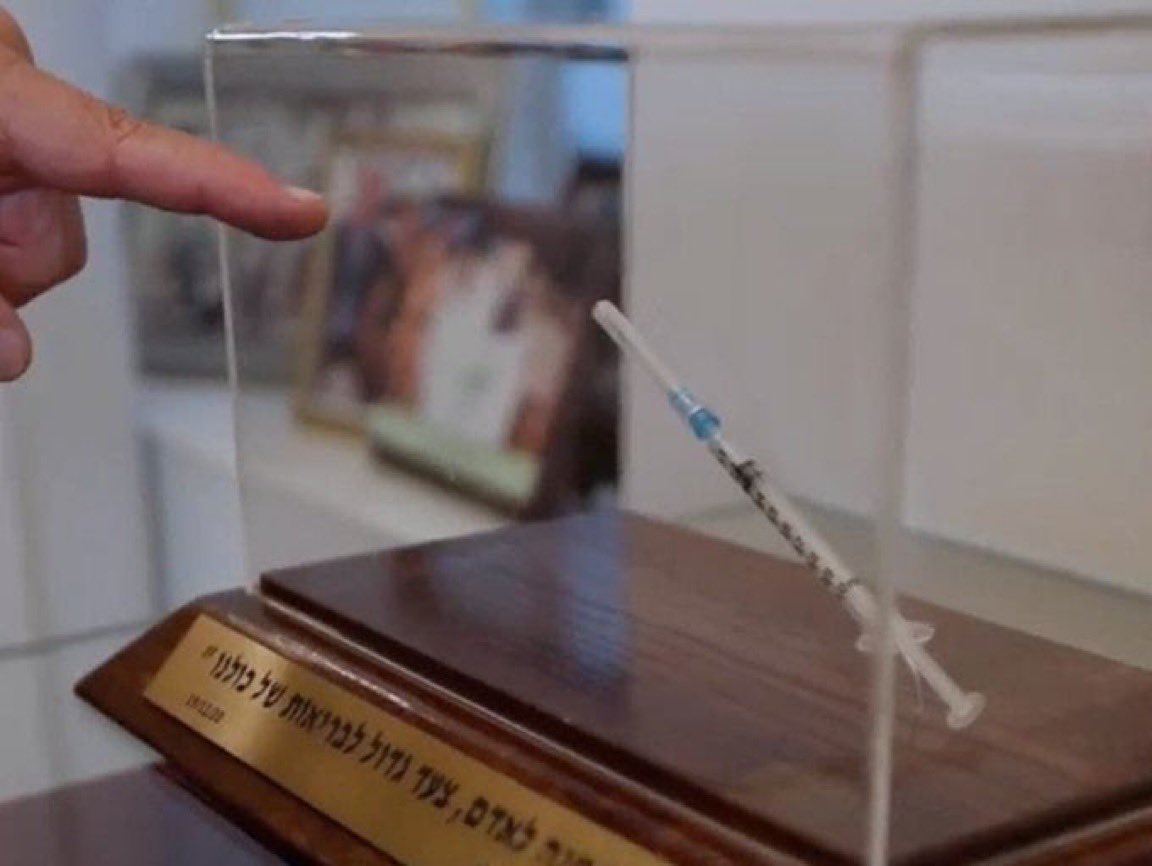 Why does Netanyahu keep a covid syringe as a trophy in his office?