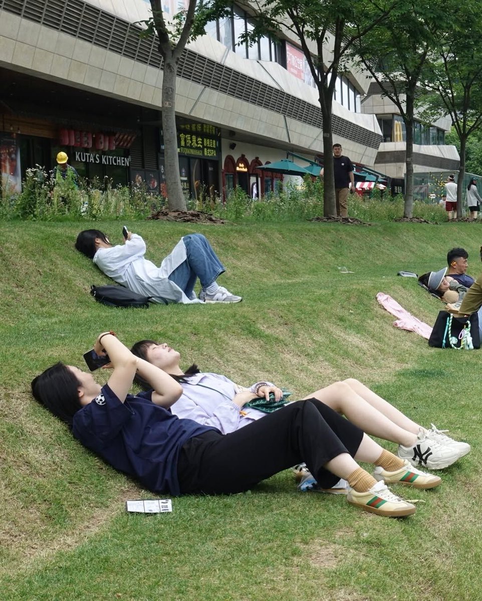 hutdesigns's tweet image. In Shanghai there’s a tiered public lawn known as the Lounge Lawn, designed specifically so people can lie down, rest, or nap comfortably during short breaks in between work