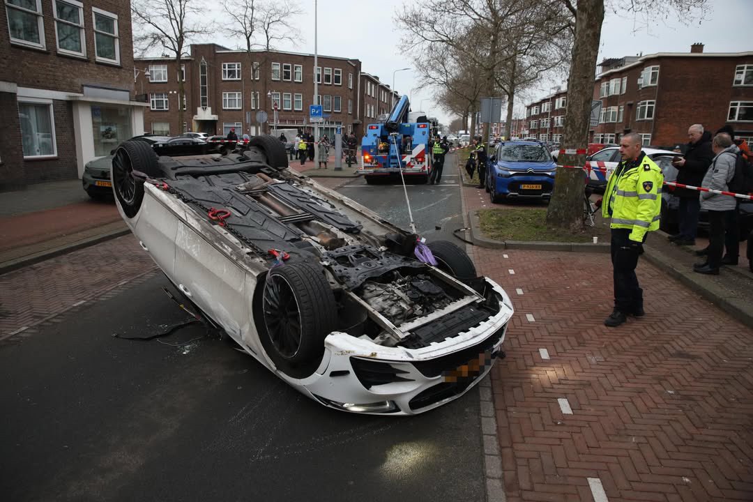 Auto op zijn dak na botsing in Den Haag