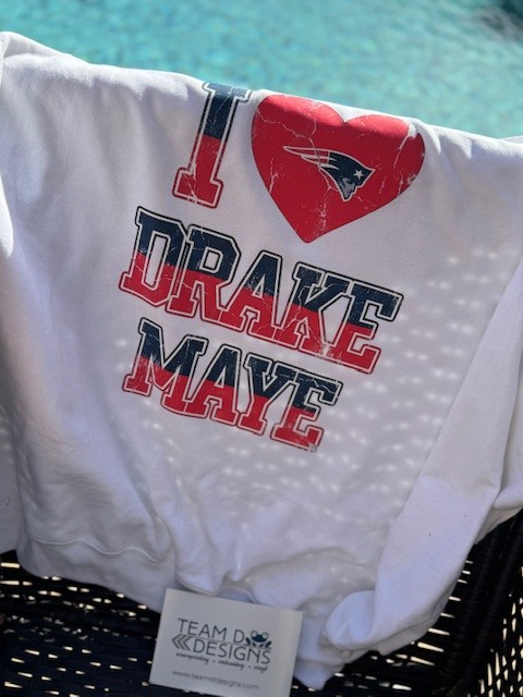 teamddesigns's tweet photo. 🏈Calling all Drake Maye fans! ❤️Our I Love Drake Maye tees and crews are the perfect way to display your team spirit! Don’t miss out—grab yours while supplies last! ⚡️👇 Shop here: https://t.co/A2Uuv4E42A #TeamSpirit #DrakeMaye #ShopNow https://t.co/aHm6GfLwWZ