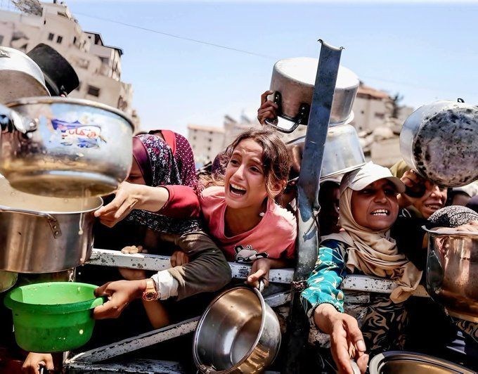 Samar41655217's tweet photo. Small hands hold the weight of gnawing hunger. In crowded streets, children line up for food. Steam rises from shared pots, but hope feels dwindling. This is the quiet suffering of besieged families where a single meal becomes the day's greatest triumph.#GRAMMYs #Epstein https://t.co/acPH9B6i1A