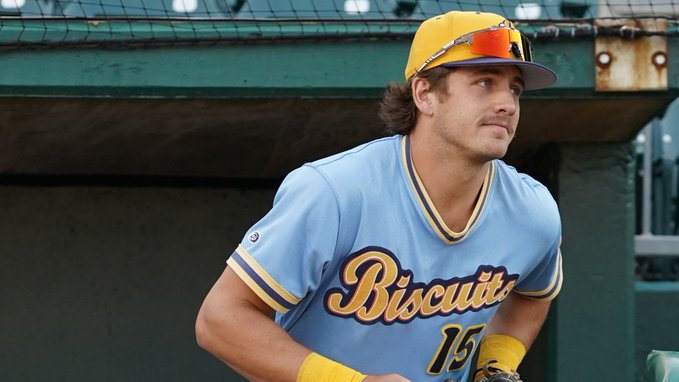 Colton Ledbetter jogs out of the dugout in a blue Montgomery Biscuits jersey