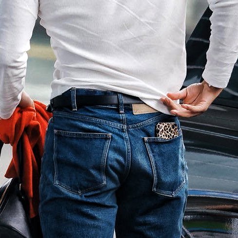 taehyung pairing a henley with flared jeans red scarf and a cheetah print phone case to achieve the ultimate slutty combo