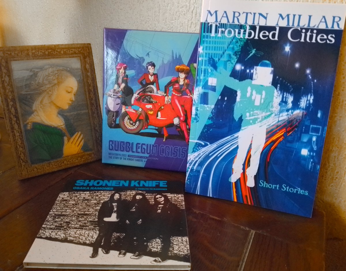 Keeping me company at my writing desk today: The Madonna of the Rock by Fra Filippo Lippi. Troubled Cities, my book of short stories. Shonen Knife’s tribute to the Ramones. Bubblegum Crisis anime. Bubblegum Crisis is a great name, I wish I’d thought of it.