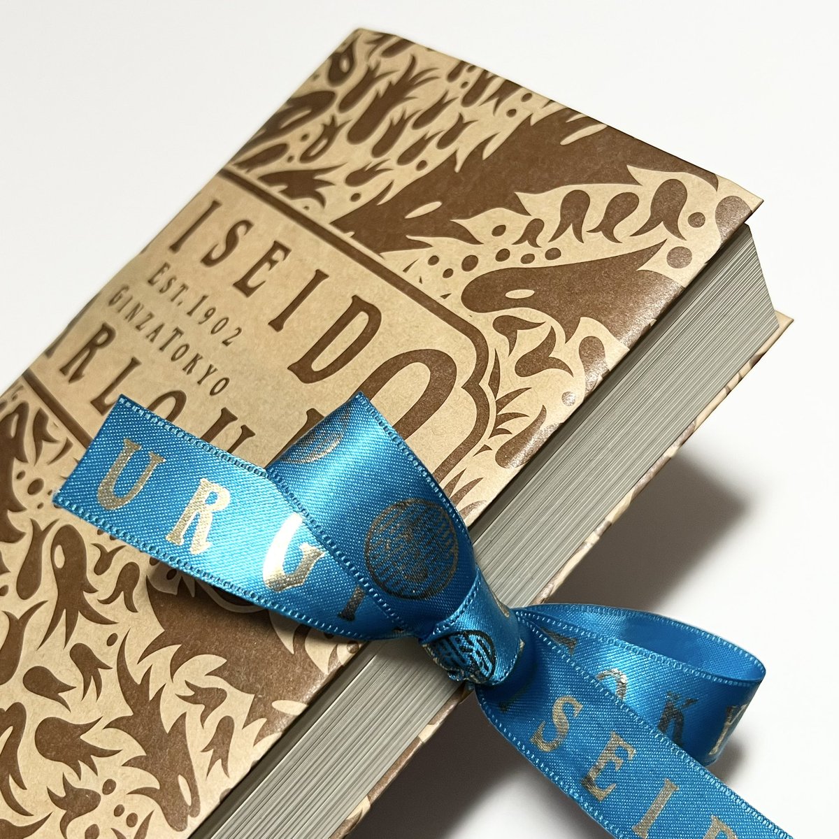 鈍器のような本のブックカバーを探していたところこちらのポストにたどり着き、推しショップの包装紙とリボンで素敵なカバーが生まれました🎀