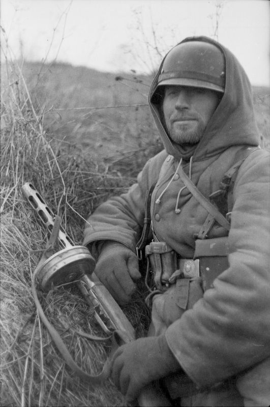 Немецкий солдат, вооруженный трофейным советским пистолетом — пулеметом ППШ-41, на позиции в поле.

1944
#WWII #WW2