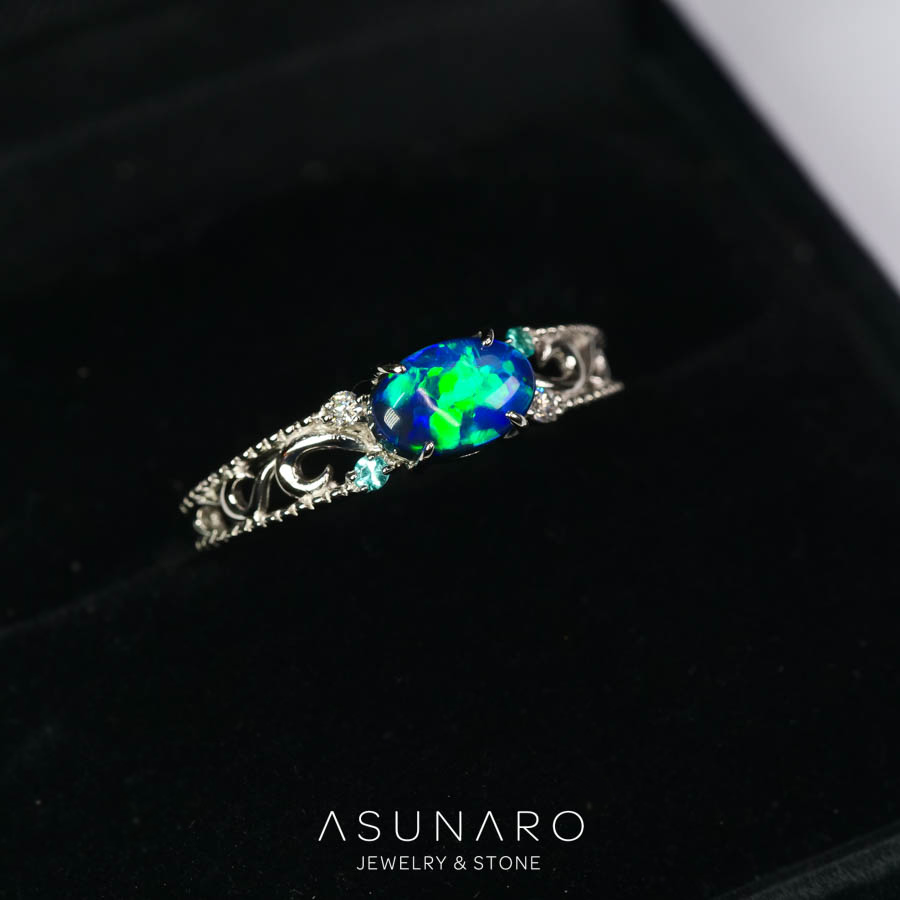 極地に煌めくオーロラのように魅惑的なブラックオパールをお仕立てさせていただきました。

ミルグレインのラインに唐草の透かし模様とダイヤを配置したアンティーク調のリング枠、横向きに配置されたオーバルのカボションがエレガントな印象を与えるデザインです。