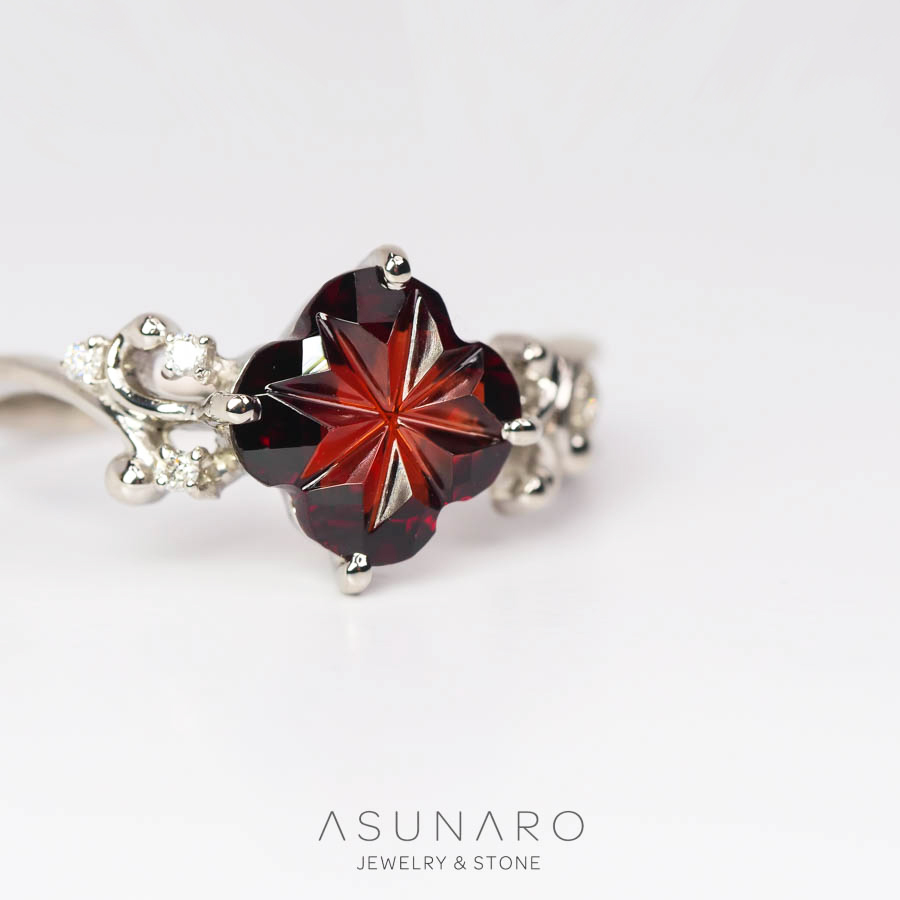 艶やかな緋色に繊細な切子カットが煌めくガーネットをお仕立てさせていただきました。

アシンメトリーな曲線と空間美が優しくモダンな印象のリング枠、可憐なフラワーシェイプのメインストーンにぴったりのボタニカルデザインです。