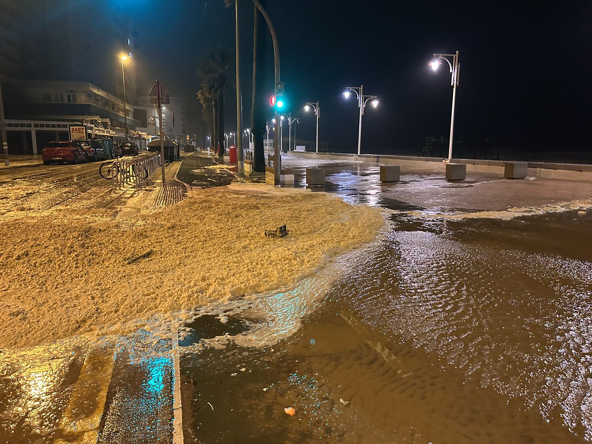 pedrofespinosa's tweet photo. No es arena. Es espuma de mar. El agua ha alcanzado esta noche el Paseo Marítimo de Cádiz https://t.co/rB0OdwezzI