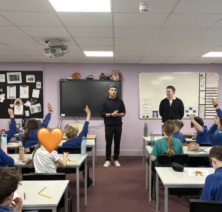 autosport's tweet photo. Lando Norris paid a very special visit to his old primary school in Bristol, where he took part in a whole-school assembly and spoke to kids about the importance of perseverance 🧡

The F1 World Champion visited every classroom, answered questions, signed items, and even waved the chequered flag for a schoolyard scooter race 🏁

He made sure every pupil received a gift before he left 🎁